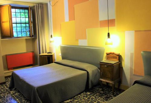 a hotel room with two beds and a window at Hotel Diana & Depandance in Lucca