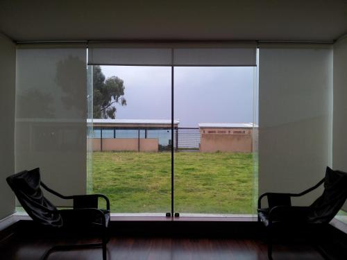 two chairs sitting in front of a large window at Hotel Onkel Inn Torres de Copacabana in Copacabana