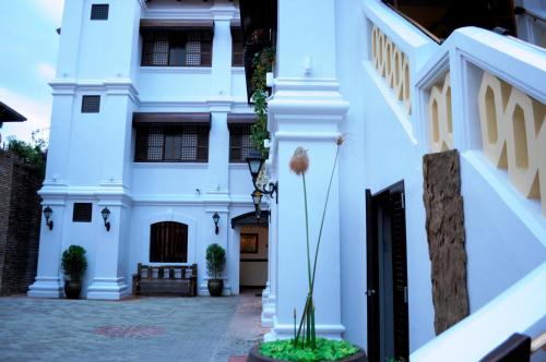 a white house with a courtyard in front of it at Hotel Veneto De Vigan in Vigan