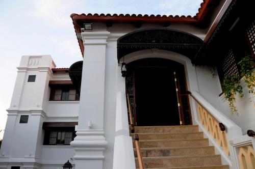 a white building with stairs leading to the door at Hotel Veneto De Vigan in Vigan