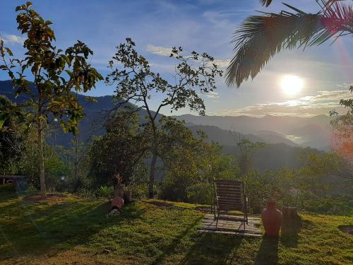 a view of the mountains with a vase in the grass at Pousada Sítio Rústicu's in Domingos Martins