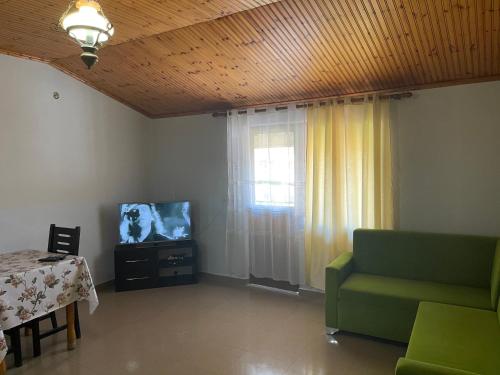 een woonkamer met een bank en een televisie bij My Hostel in Shkodër