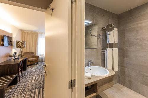 a bathroom with a sink and a shower at Hotel Malpertuus in Riemst