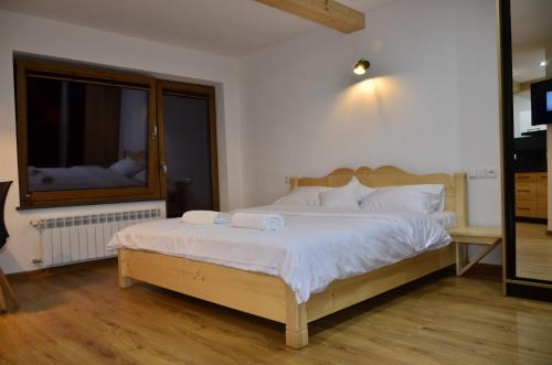 a bedroom with a bed with white sheets and a window at Apartamenty Szalaya 29 in Szczawnica