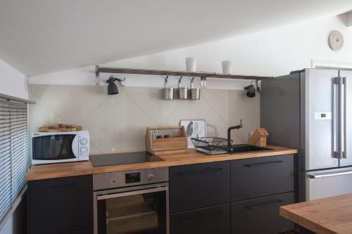 eine Küche mit einer Theke, einer Mikrowelle und einem Kühlschrank in der Unterkunft Apartments Leut in Podgora
