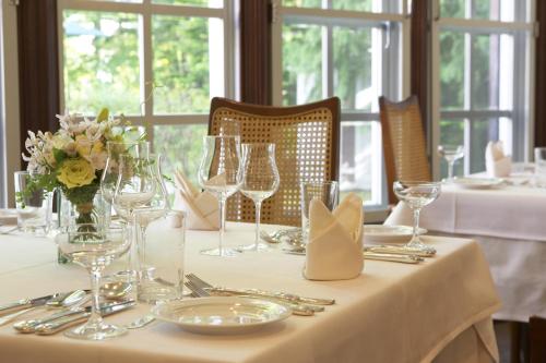 una mesa con un mantel blanco con gafas y flores en Kyu Karuizawa Hotel Otowa No Mori, en Karuizawa