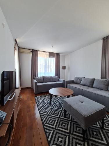 a living room with two couches and a tv at Apartman Esperanza in Vrnjačka Banja