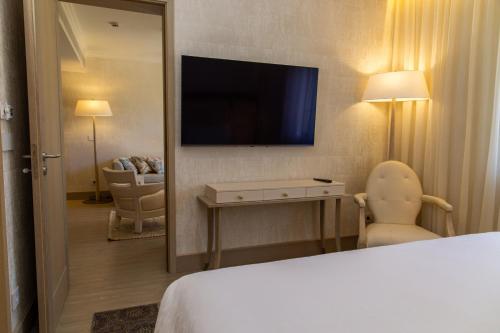 a hotel room with a television and a bed at Vila Alba Resort in Carvoeiro