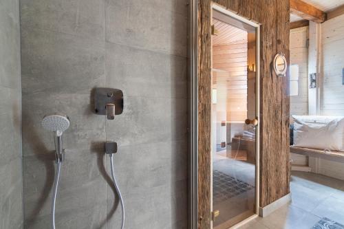 a shower in a bathroom with a mirror at Nautic Strandhotel in Sierksdorf