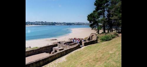 a group of people standing on a wall near a beach at Tente 3 chambres, petit camping familial vue mer in Plestin-les-Grèves