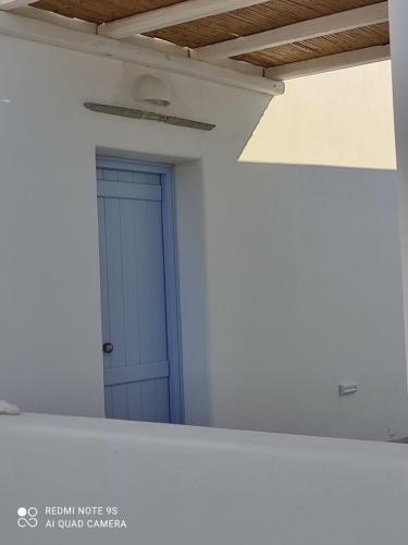 an empty room with a blue door in the ceiling at Stilvi Milos in Plaka Milou
