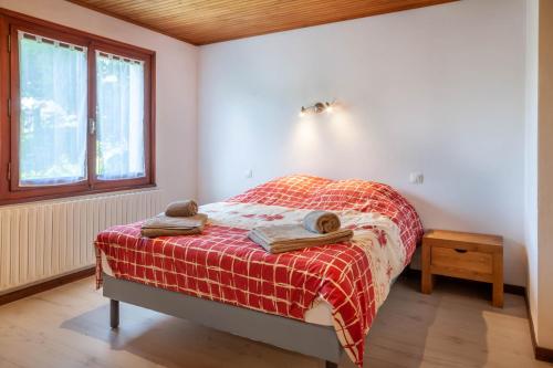 une chambre avec un lit avec une couverture rouge dans l'établissement Egralets 2b, à Morzine
