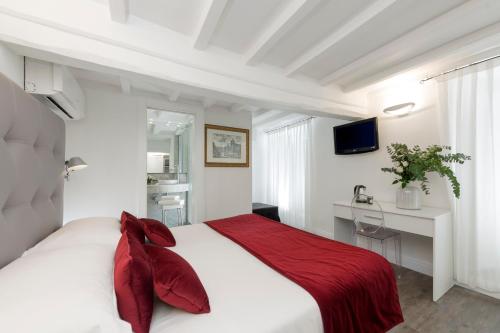 a bedroom with a large white bed with red pillows at Hotel Navona in Rome