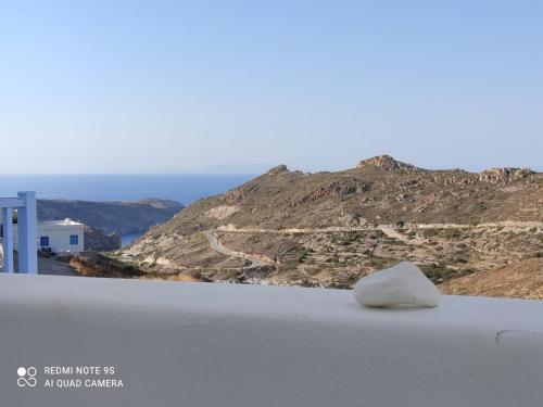 a rock sitting on the edge of a roof with a mountain at Stilvi Milos in Plaka Milou