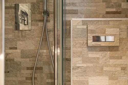 La salle de bains est pourvue d'une douche avec une porte en verre. dans l'établissement Holiday House Livigno, à Livigno