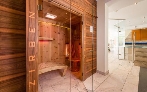una puerta de cristal en una habitación con una pared de madera en Hotel Moserhof en Reutte