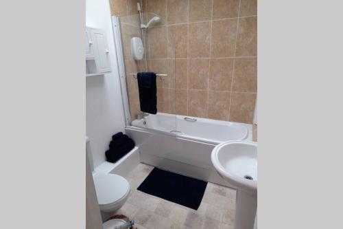 a bathroom with a tub and a toilet and a sink at Town centre cottage in Tewkesbury