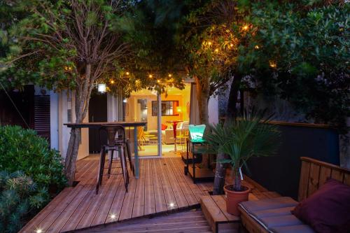a wooden deck with a table and chairs and trees at Les Terrasses Levantines in Île du Levant