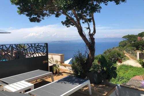 a patio with a table and a view of the ocean at Les Terrasses Levantines in Île du Levant