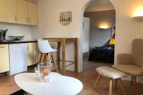 a kitchen and living room with a table and chairs at Les Terrasses Levantines in Île du Levant
