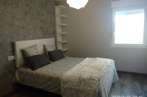 a bedroom with a bed with two pillows and a window at Apartamento Casa Barquero Bronchales in Bronchales