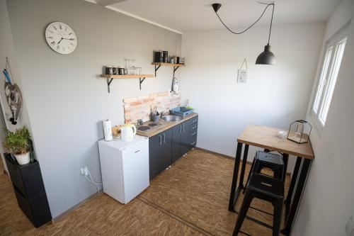 a kitchen with a sink and a table and a clock at OPG Dokić in Kopačevo