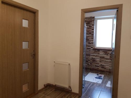 a room with a door and a brick wall at Aris Apartment in Hunedoara