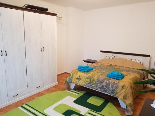 a bedroom with a bed and a cabinet and a rug at Aris Apartment in Hunedoara