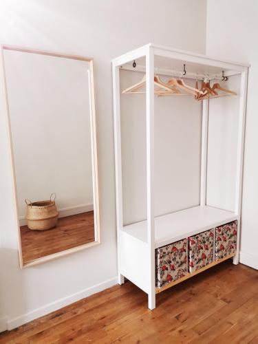 une armoire blanche avec deux miroirs dans une pièce dans l'établissement Appartement INDÉPENDANT centre ville 1chambre, aux Herbiers
