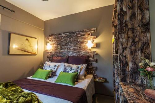 a bedroom with a bed with green pillows at Side Sea View Apartment in Neoi Epivates