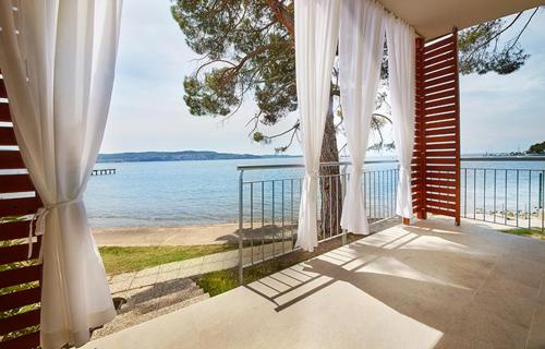 a balcony with a view of the ocean from a house at Adria Apartments - Hotel & Resort Adria Ankaran in Ankaran