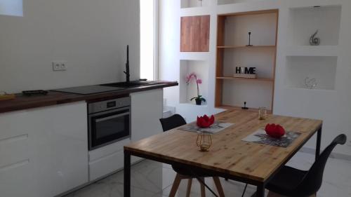 a kitchen with a wooden table with red flowers on it at 04A2 - Paradise Love In Provence - le loft étoilé - spa privatif in Reillanne