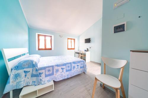 1 dormitorio azul con 1 cama y 1 silla en Aloha en San Benedetto del Tronto
