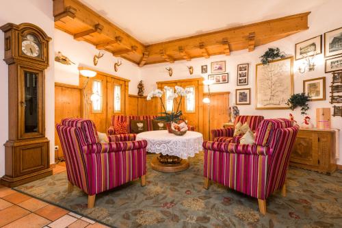 a living room with red chairs and a table at Hotel Moserhof in Reutte