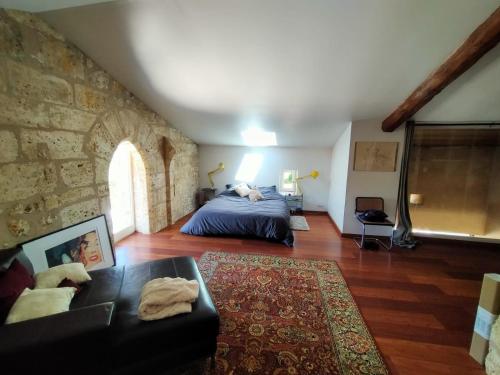 ein Schlafzimmer mit einem Bett und einer Steinmauer in der Unterkunft Grande villa au coeur de la Dordogne in Paussac-et-Saint-Vivien