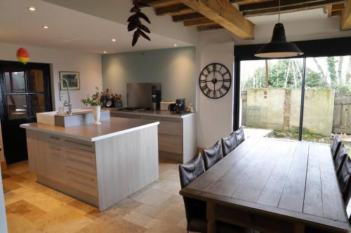 a kitchen with a wooden table and a dining room at La Maison de Louis in Francon