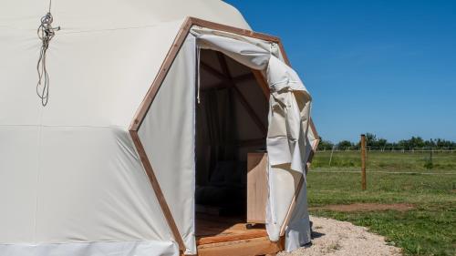 une tente avec une porte ouverte dans un champ dans l'établissement Dome Géodésique, à Gizay