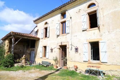 an old stone building with a bench in front of it at La Maison de Louis in Francon