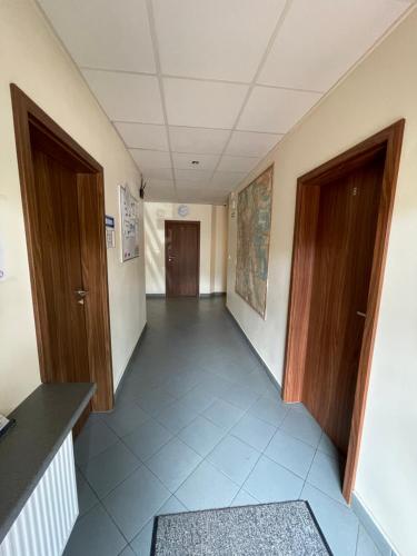 an empty hallway with two wooden doors and a hallway sidx sidx at ANNA NOCLEGI in Raszyn