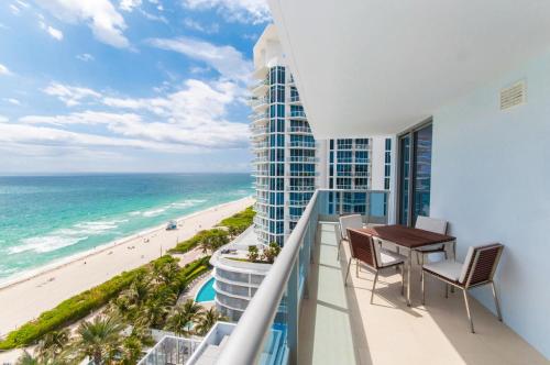 balcón con mesa y sillas y vistas a la playa en Monte Carlo by Miami Ambassadors, en Miami Beach