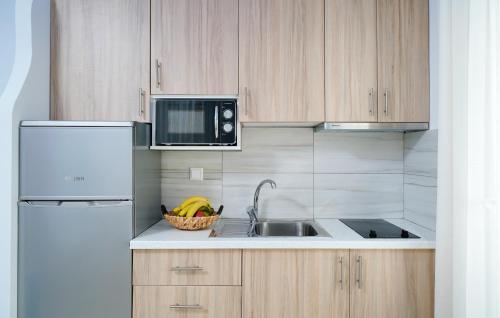 a kitchen with a sink and a microwave at Tarsa's House by the Sea in Skala Marion