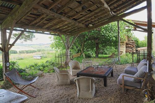 a group of chairs and a table under a pavilion at La Maison de Louis in Francon
