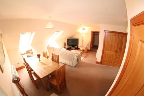 uma vista superior de uma sala de estar com uma mesa e um sofá em Macallen em Nairn