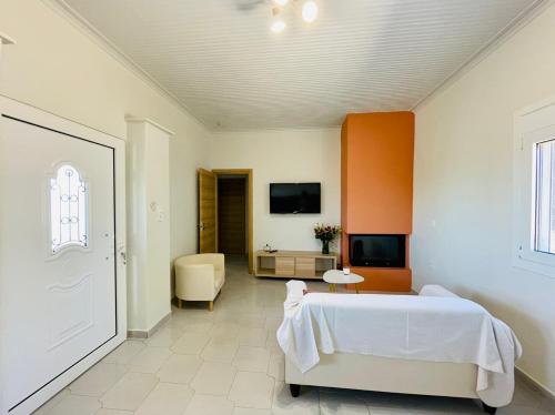 um quarto com uma cama branca e uma televisão em Agrothi em Marathopolis