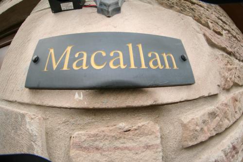 a sign on the side of a stone wall at Macallen in Nairn