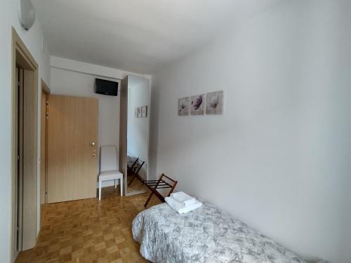 - une chambre avec un lit et une chaise dans l'établissement Hotel Da Marco, à Vigo di Cadore
