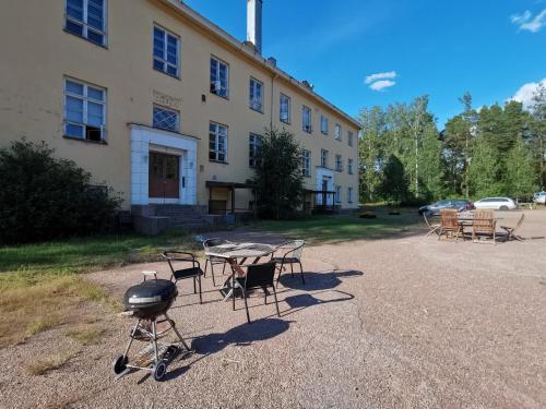 a grill and tables and chairs in front of a building at Captivating 4-Bed Apartment in Kotka SaunaFacility in Kotka