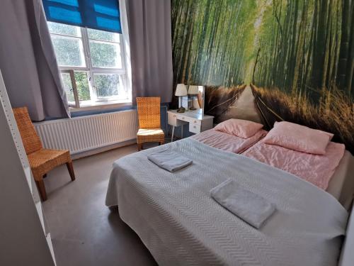 a bedroom with a bed and a painting on the wall at Captivating 4-Bed Apartment in Kotka SaunaFacility in Kotka