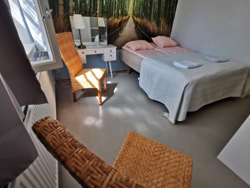 a view of a bedroom with a bed and a chair at Captivating 4-Bed Apartment in Kotka SaunaFacility in Kotka