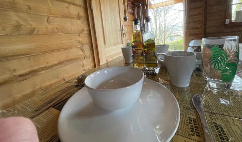 a table with white cups and plates on it at Retro private Lodge with hot tub Nr Dartmoor in Newton Abbot